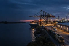 Cargo ship, containers, rail, trucks, warehouse and factory in a global supply chain.