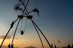 People on a bamboo swing during the Dashain festival in Nepal at sunset